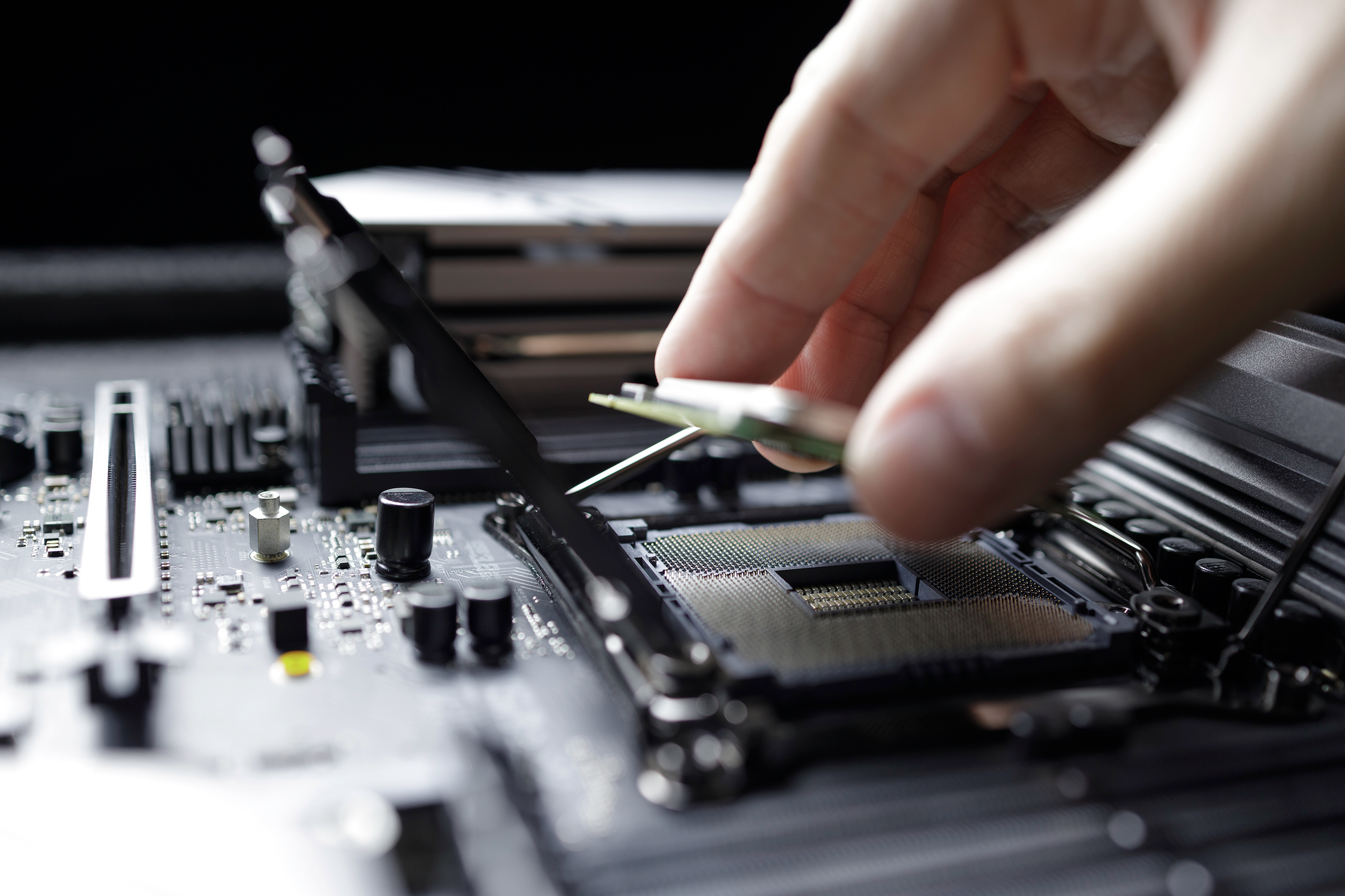 A close-up of a hand placing a circuit board.