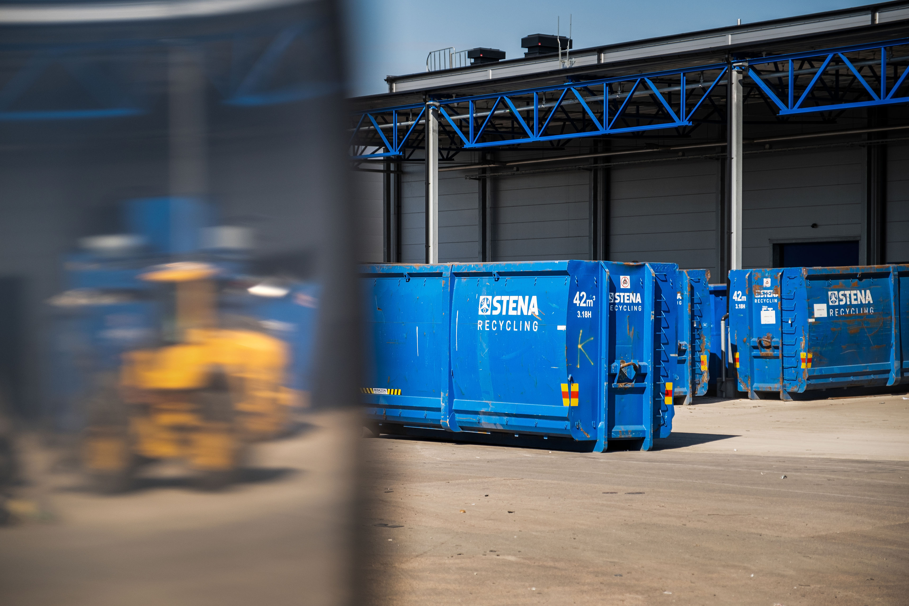 Blue containers and the reflection of a truck
