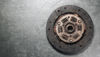Clutch disc resting on a metallic surface, ready for installation.