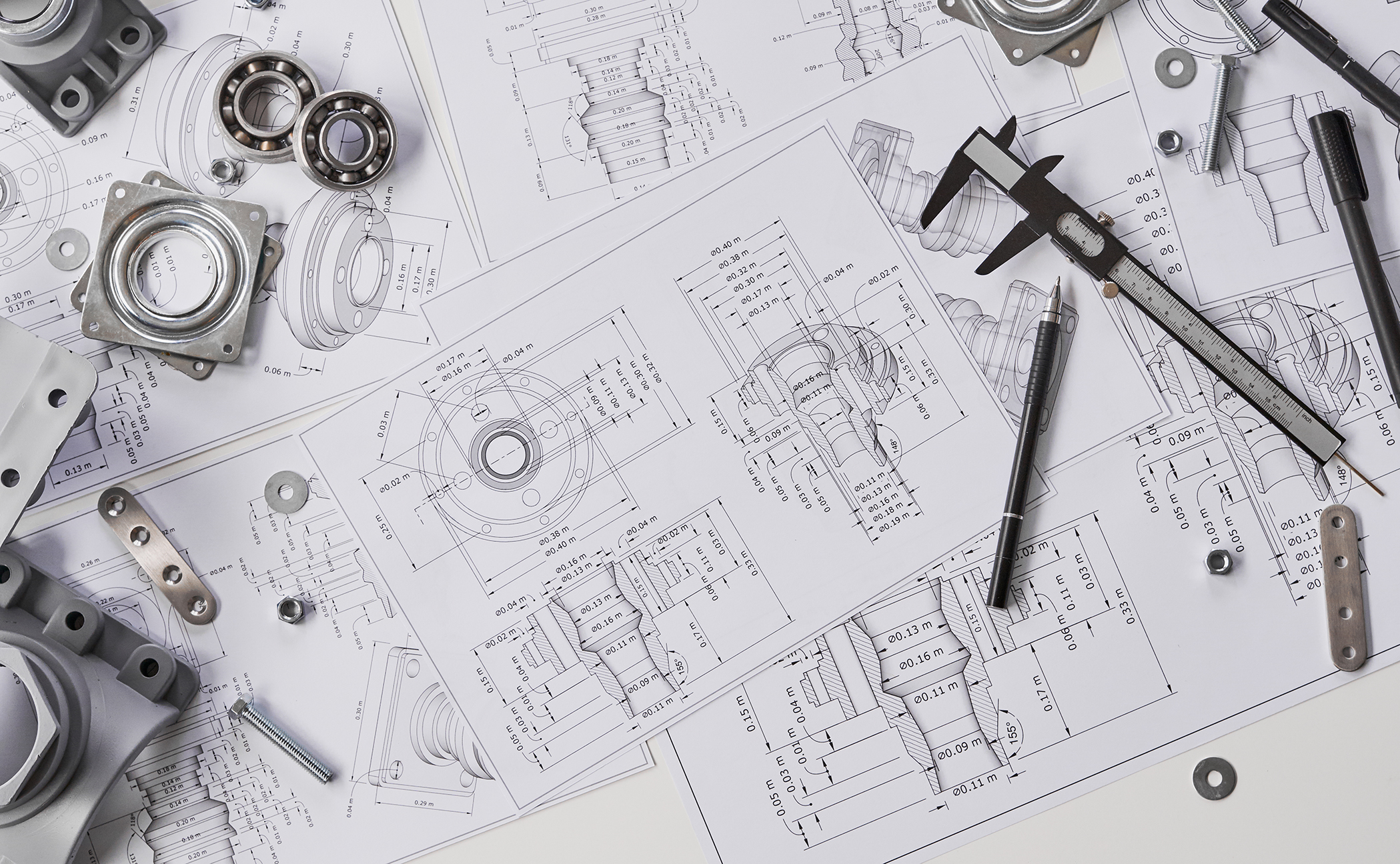 Mechanical components and tools on engineering blueprints, including bearings, calipers, and screws.