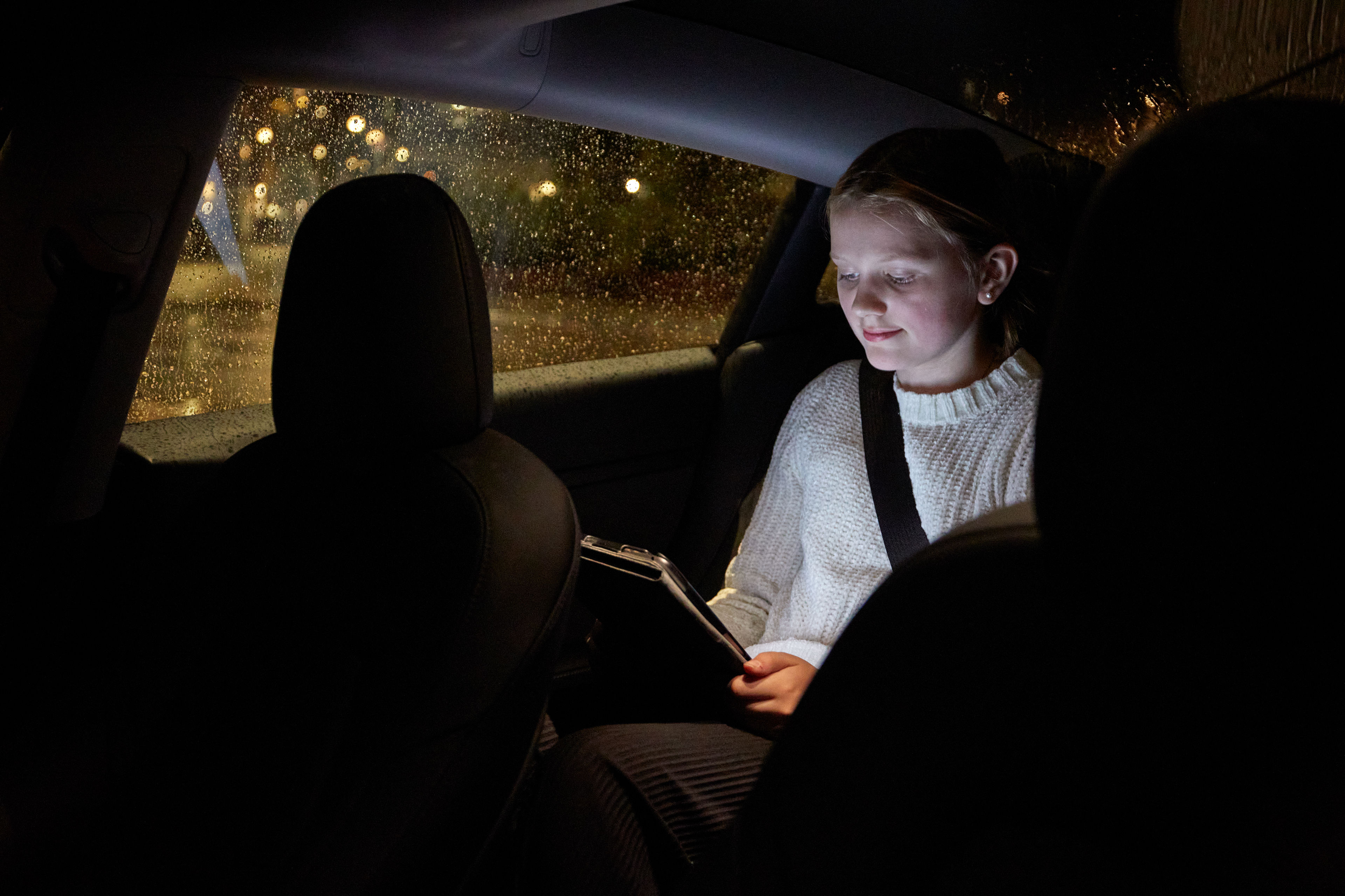 A close-up of two hands holding a mobile phone with a cracked screen.