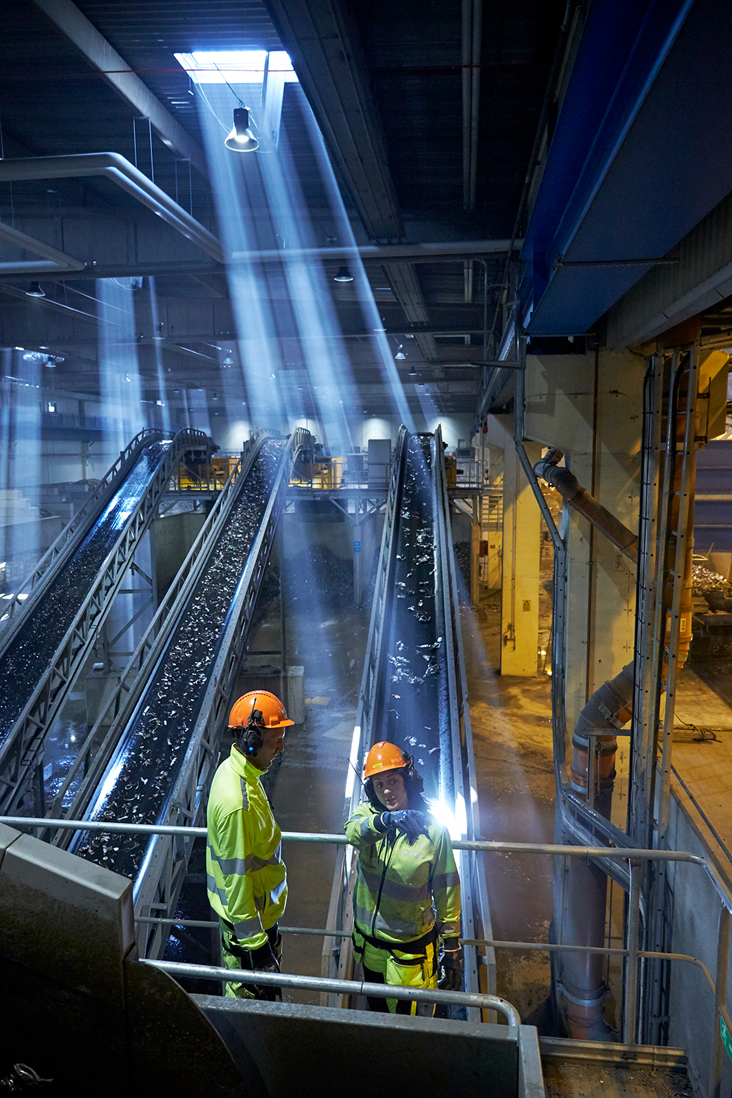 Two Stena Recycling employees in hi-vis clothing and protective work together at Stena Nordic recycling Center.