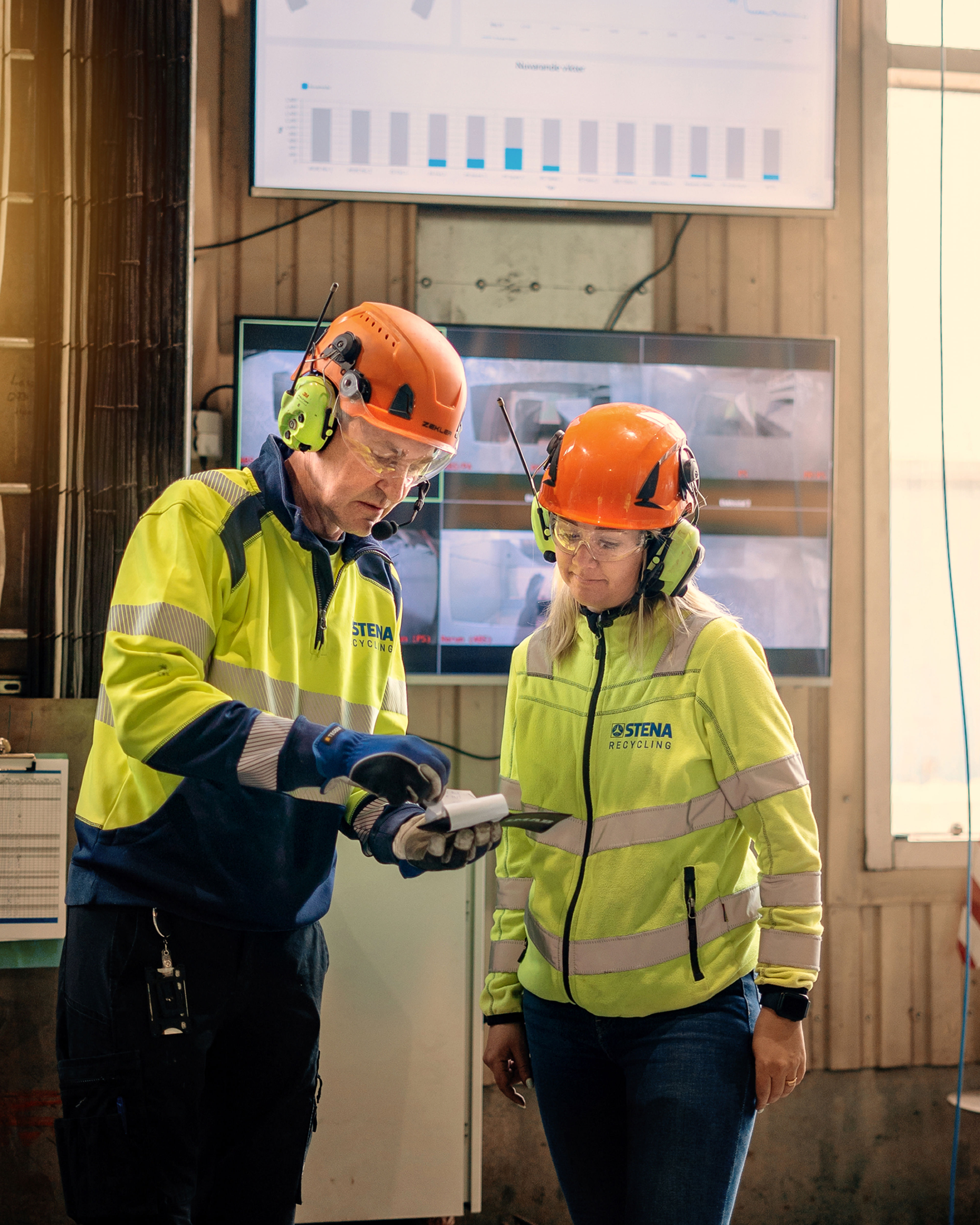 To Stena Recycling-medarbejdere i beskyttelsesudstyr med høj refleksfunktion.