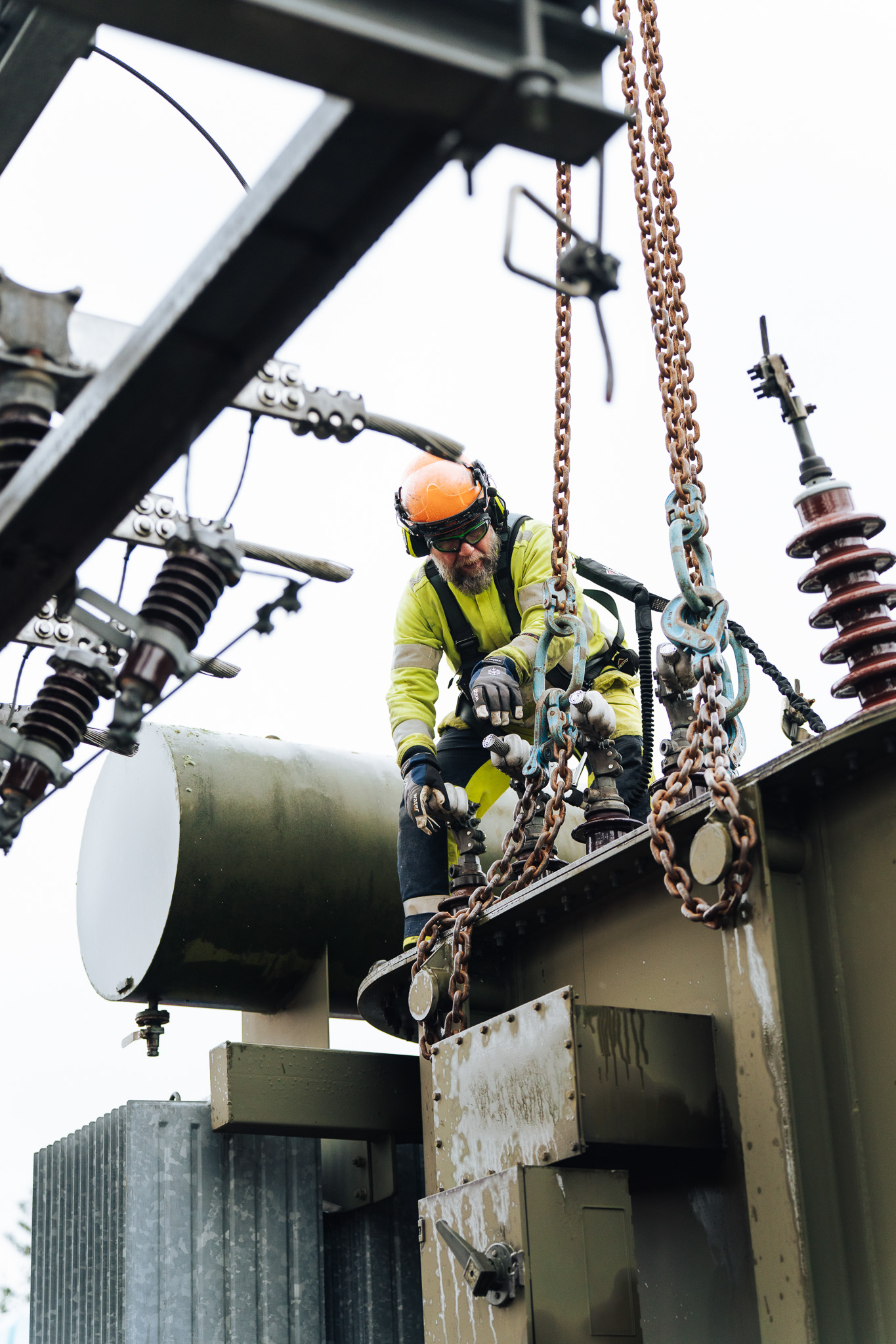 varselklädd arbetare uppe på en transformator