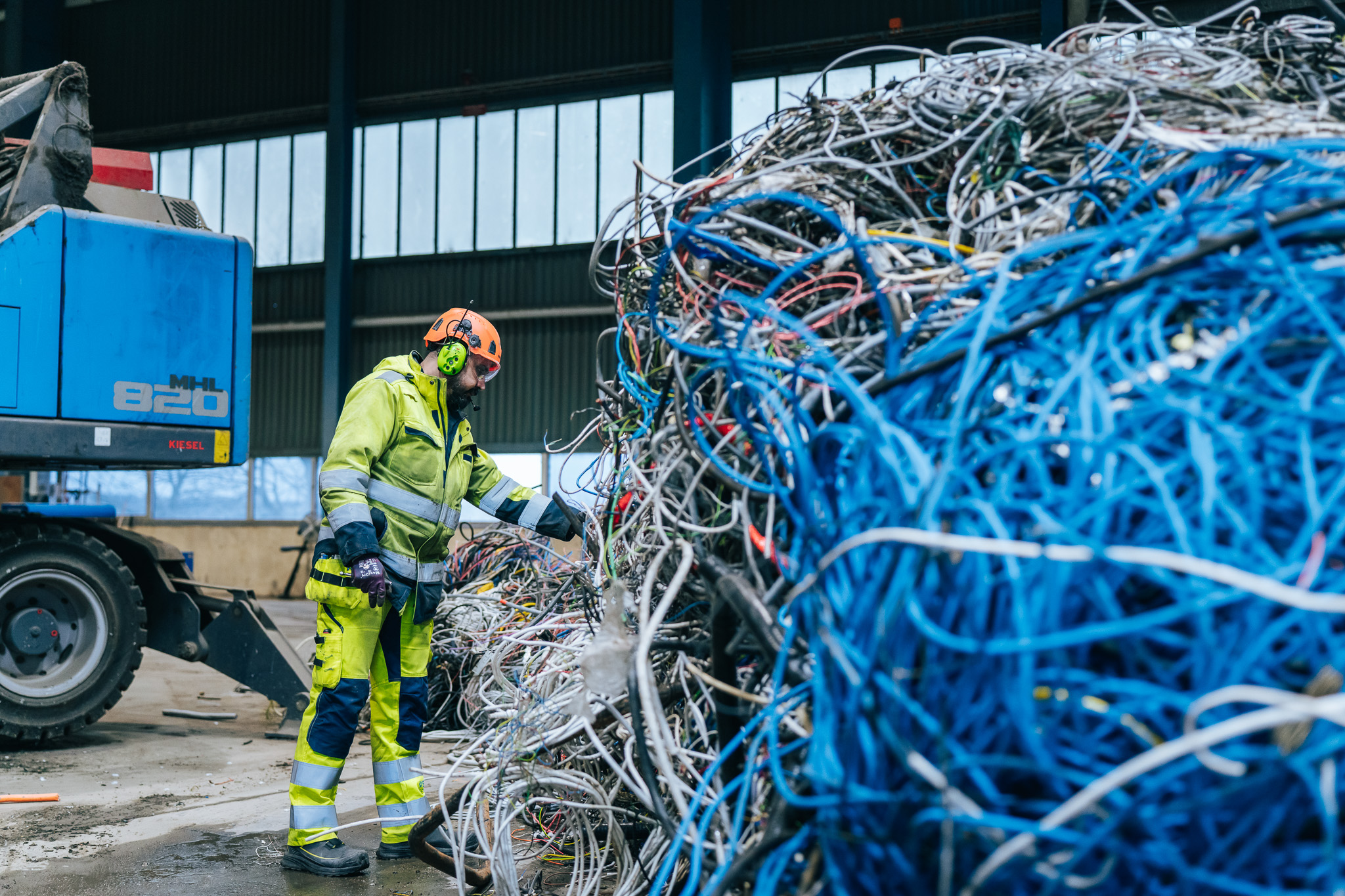 Man i varselkläder som inspekterar kabel
