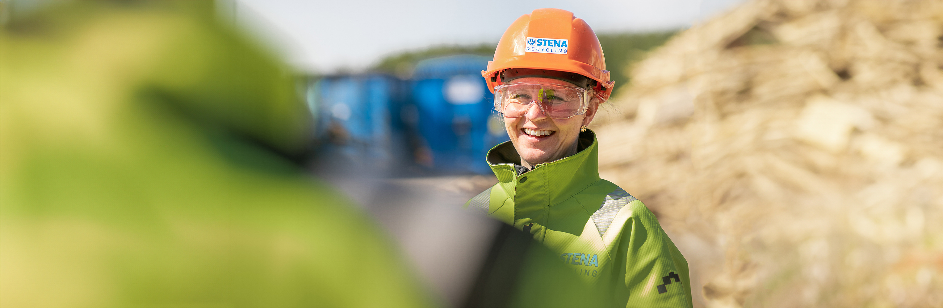 A smiling female Stena Recycling employee in protective clothing