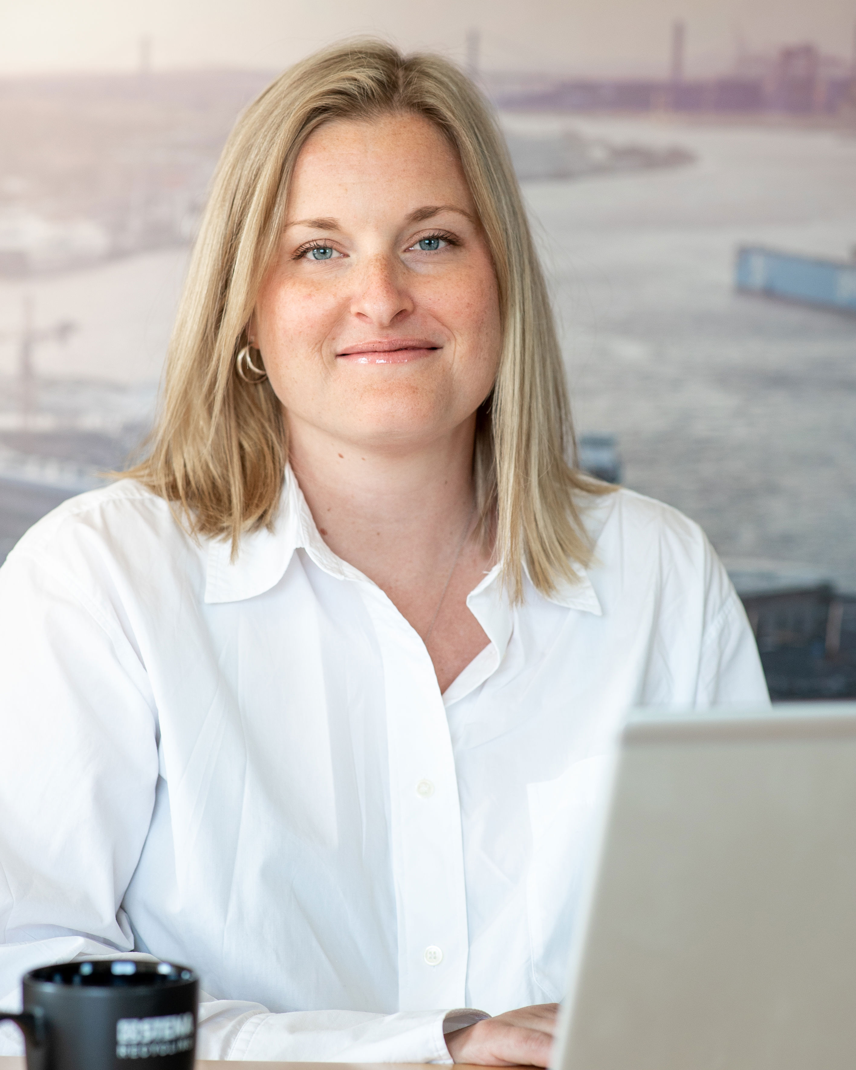 A female Stena Recycling employee wearing a white shirt with Gothenburg – home of Stena Recycling –  in the background.