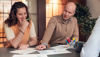 Two people in front of board